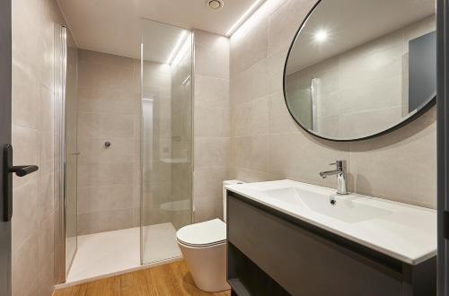 W łazience znajduje się umywalka, toaleta i lustro. w obiekcie Rentalmar Suites Salou Families Only w Salou