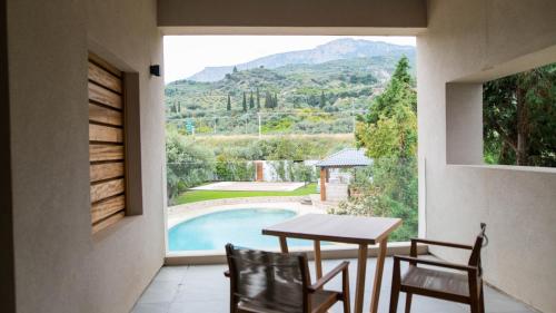 a balcony with a table and chairs and a view of a pool at Alissachni SeaSide Hotel in Derveni