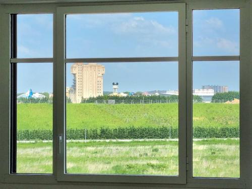 a window with a view of a green field at Suite Riviera - Vue Disneyland in Chessy