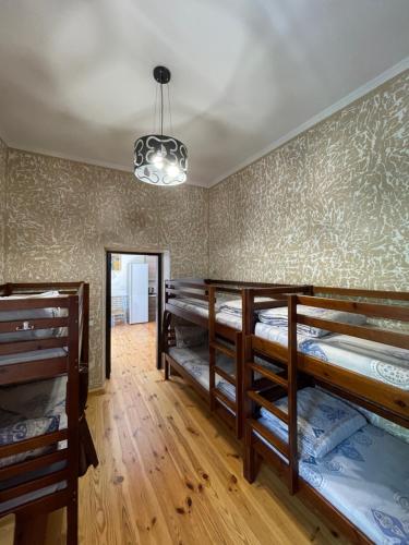 a room with three bunk beds and a chandelier at SWEET hostel in Vinnytsya