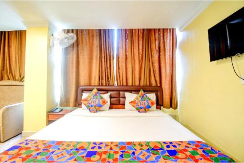 a bedroom with a large bed with colorful pillows at FabHotel Raj Darbar in Salua