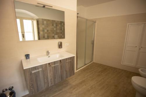 een badkamer met een wastafel, een spiegel en een toilet bij Panta Rei in Lamezia Terme