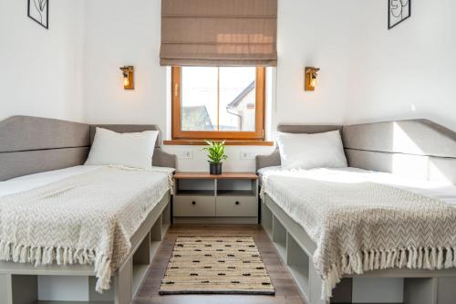 two beds in a room with a window at La Șura in Şura Mică