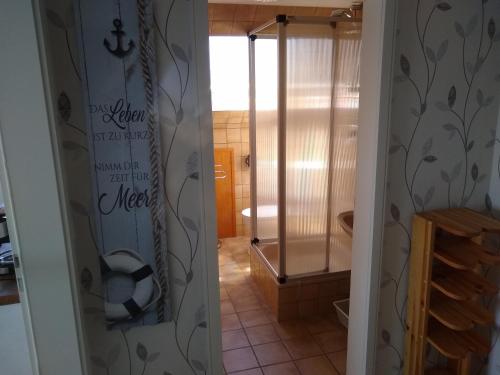 uma casa de banho com um chuveiro e um WC num quarto em FeWo Nordlicht em Hage