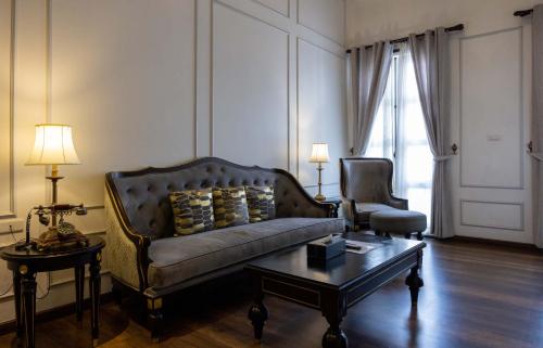 a living room with a couch and a coffee table at Le Thatluang D'oR Boutique Hotel in Vientiane