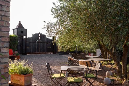 a patio with a table and chairs and a church at Country House Art and Garden in Monte Antico