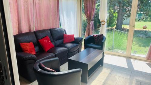 a living room with a couch and chairs and a table at La petite maison de Paule in Amilly