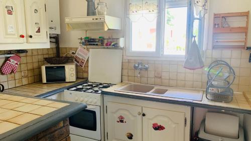 a kitchen with a sink and a stove top oven at La petite maison de Paule in Amilly