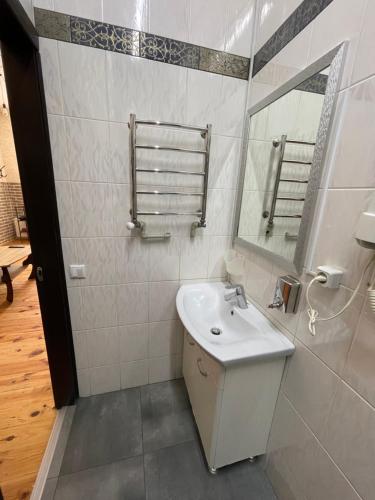 Baño blanco con lavabo y espejo en SWEET hostel, en Vínnytsia