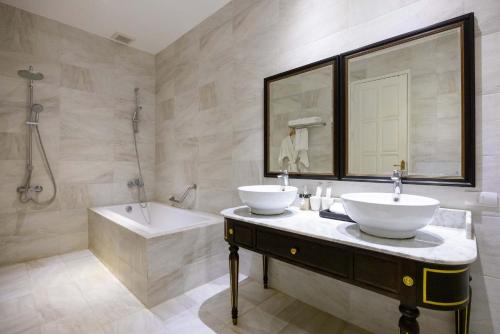 a bathroom with a sink and a bath tub and a sink at Le Thatluang D'oR Boutique Hotel in Vientiane
