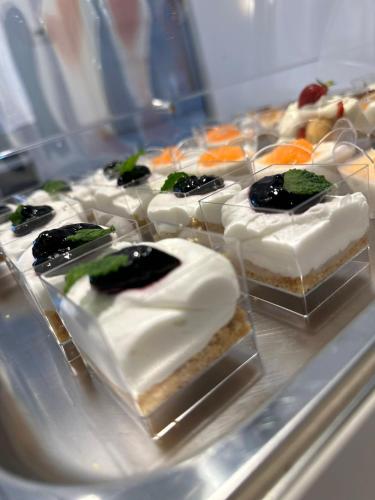 a tray of cakes with white frosting and fruit on it at HOTEL MOSAICO in Matera