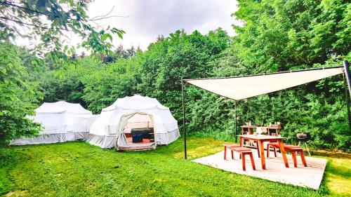 duas tendas num campo com uma mesa na relva em Glamping Camp mit Komfortzelten in Losheim am See em Losheim