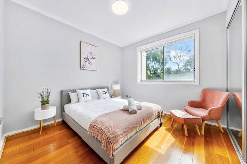 a bedroom with a bed and a chair and a window at cosy Chatswood retreat, conventience location in Sydney