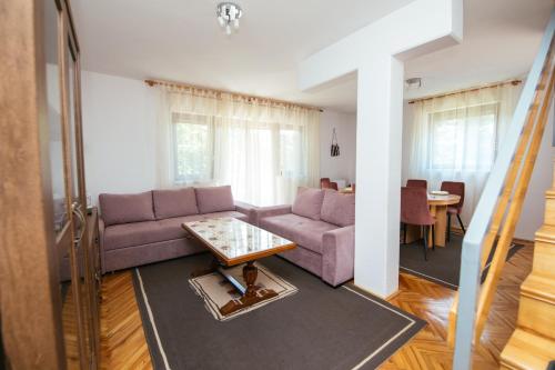 a living room with a purple couch and a table at Weeksa Vacation Home in Duga Resa