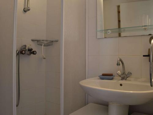 une salle de bain blanche avec un lavabo et une douche dans l'établissement Appartement T2 avec terrasse, piscine, proche plage à Saint-Cyprien - FR-1-225D-26, à Saint Cyprien Plage