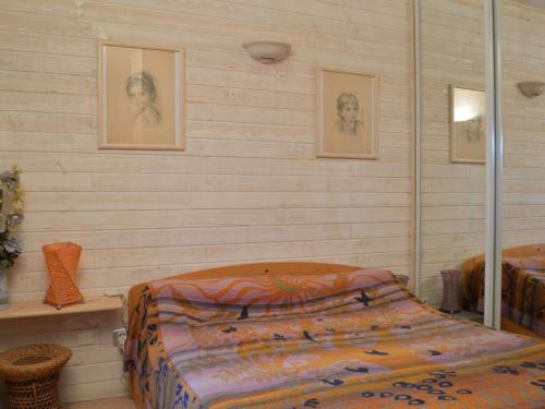 - une chambre avec 2 lits et des photos sur le mur dans l'établissement Appartement T2 avec piscine, jardinet et parking à 250m de la plage à Saint-Cyprien - FR-1-225D-22, à Saint Cyprien Plage