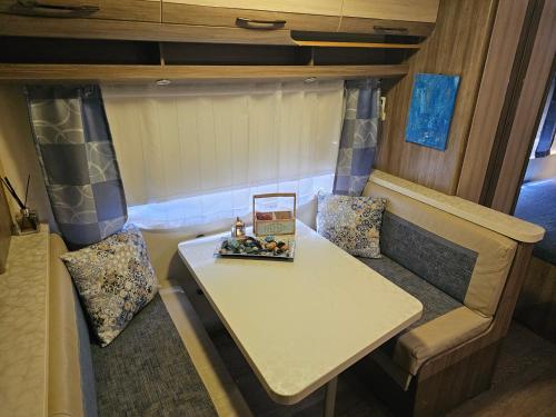 埃拉特的住宿－קרוואן באילת，拖车内的桌子和沙发,配有桌椅