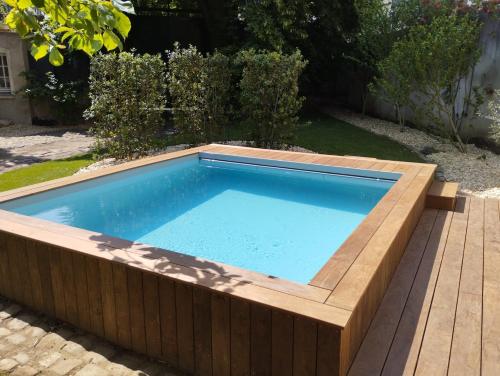 uma grande piscina com um deque de madeira e uma piscina em Hôtel du marquis De Broc em Le Mans