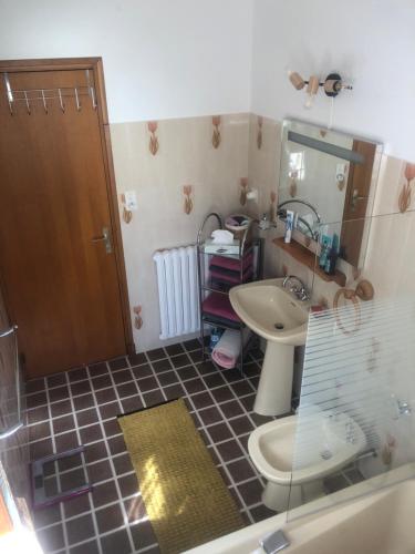 a bathroom with a sink and a toilet and a mirror at Le petit gîte in Saint-Étienne-le-Laus