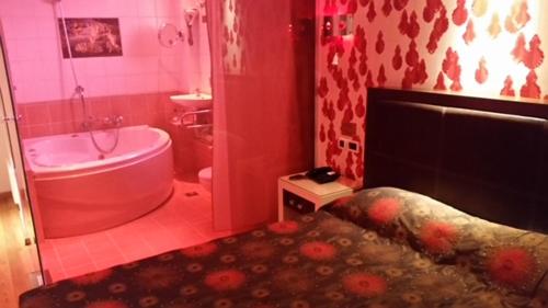 a pink bathroom with a tub and a sink at HOTEL PRIVE in Skaramangás