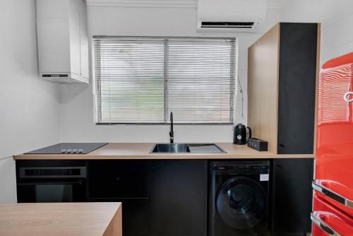 a kitchen with a sink and a washing machine at The Palms At Palm Cove in Palm Cove