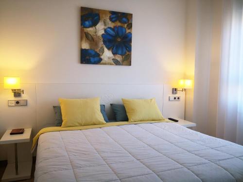 um quarto com uma grande cama branca com almofadas amarelas em Apartamento en Resort de lujo. Golf y Playa em La Antilla