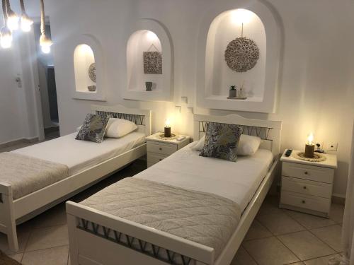 two beds in a room with two lights on them at Francesca Secret in Mikonos