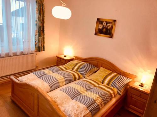 Braunegger-Hof Gasthof Mayer في Braunegg: غرفة نوم بسرير خشبي مع وسادتين