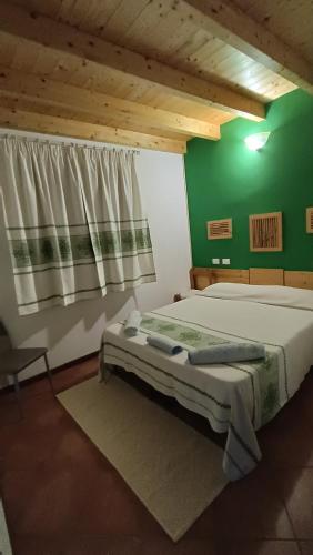 a bedroom with a bed and a green wall at B&B Kikina in Austis