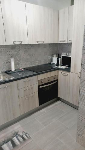 une cuisine avec des armoires blanches et un four à plaques de cuisson dans l'établissement Chez Bianca Les Coquelicots Les Lucioles, à Menton