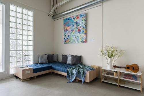 ein Wohnzimmer mit einem blauen Sofa und einer Gitarre in der Unterkunft Timios Inn 提米好旅 in Changhua