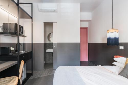 a bedroom with a white bed and a kitchen at MARCANTONIO HOME ROME - Vatican - in Rome