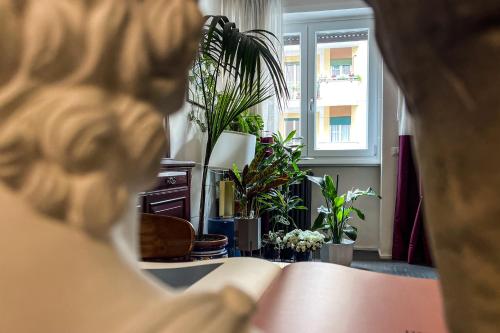 a woman is looking at a room with plants at MARCANTONIO HOME ROME - Vatican - in Rome