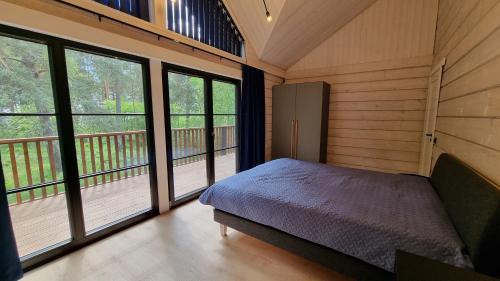 ein Schlafzimmer mit einem Bett in einem Zimmer mit Fenstern in der Unterkunft Peipsi Villad in Kuru