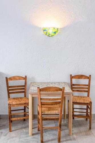 a table with two chairs and a plate on the wall at Brunis Apartments in Nei Poroi
