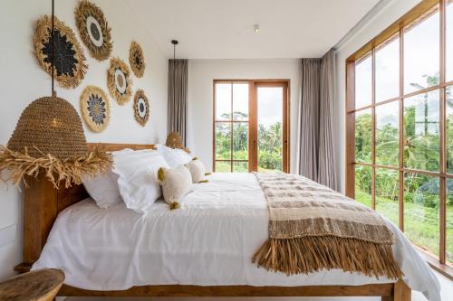 En eller flere senge i et værelse på Tembaga Villa by EVDEkimi Ubud
