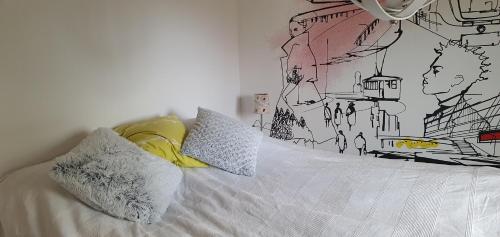 1 dormitorio con 1 cama con un dibujo en la pared en Gårdshuset i Simrishamn, en Simrishamn
