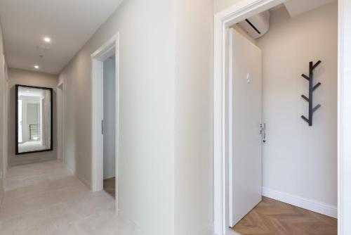 a hallway with white walls and a mirror at Télos Rooms in Villasimius
