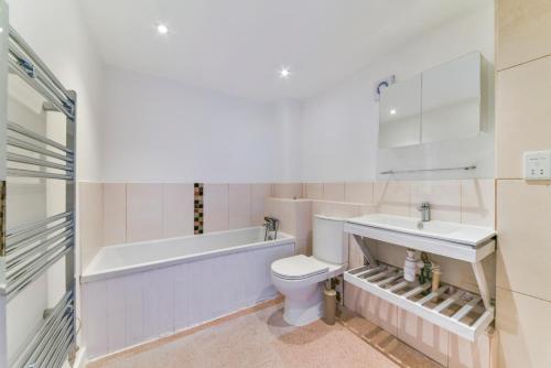 a bathroom with a tub and a toilet and a sink at Amazing 2 Bedroom Flat In Canary Wharf in London