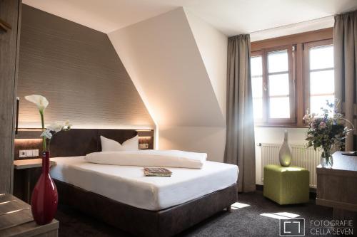 Cette chambre comprend un lit et une grande fenêtre. dans l'établissement Landhotel Geiselwind, à Geiselwind