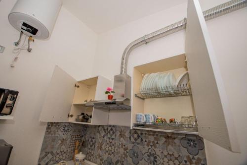 uma cozinha com armários brancos e um espelho em La Dimora di David em Bagheria