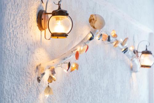 a group of lights hanging on a wall with shells at Brunis Apartments in Nei Poroi