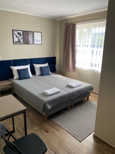 マルボルクにあるNoclegi Mazurowのベッドルーム(青い枕の大型ベッド1台付)