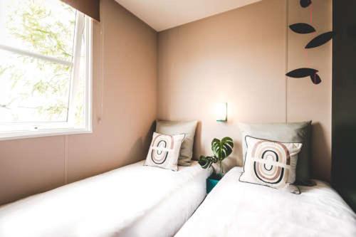 2 camas en una habitación con ventana en Camping les Dunes en Le Bois-Plage-en-Ré