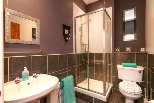 a bathroom with a toilet and a sink and a shower at Garden cottage in South Collingham