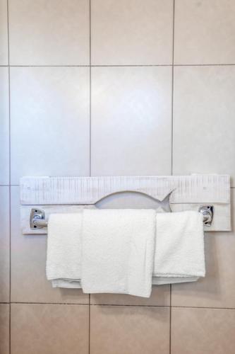 a bathroom with white towels hanging on a wall at Brunis Apartments in Nei Poroi
