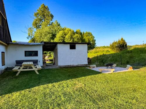 a small white building with a picnic table in a yard at Chalupa Rozálka in Cerny Dul