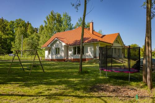 a house with a playground in front of a house at Dom Na Polanie, MyWeek in Polanica-Zdrój