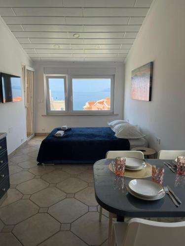 a bedroom with a bed and a table with chairs at Apartments Stone Tučepi in Tučepi