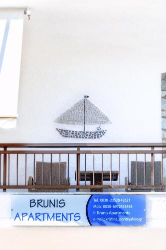 a sign for a building with a boat on the wall at Brunis Apartments in Nei Poroi